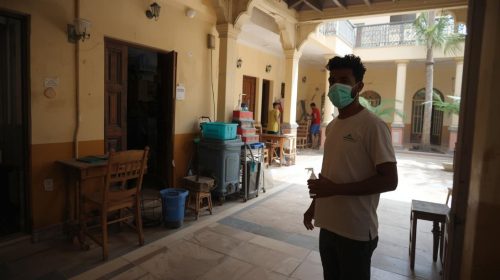 indian-society-gate-terrace-common-area-housekeeping-services-with-a-person-who-put-green-mask-sanitizer-bottle-in-hand